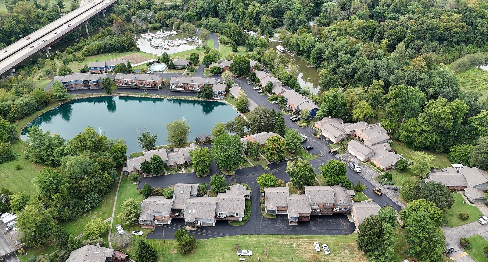Drone view of a lakeside condo community with new asphalt drives
